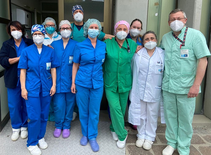 Nella foto ildottor Cipani con équipe terapia intensiva Ospedale di Pescia, un gruppo di persone, medici, infermieri e oss in divisa, all'esterno davanti una porta. Tutti con la mascherina e in divisa. 